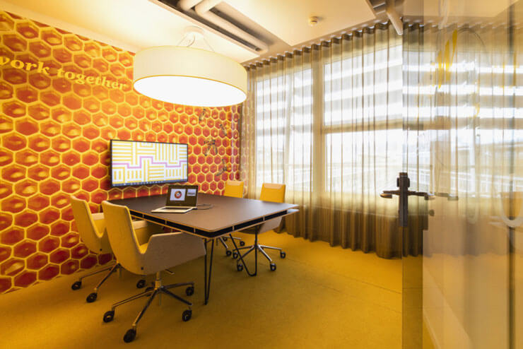 Với concept thiết kế mô phỏng tổ ong, màu nền của văn phòng chọn tông vàng sẫm ấn tượng